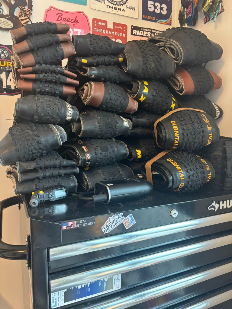 Stack of XC race tires and tire pressure tools